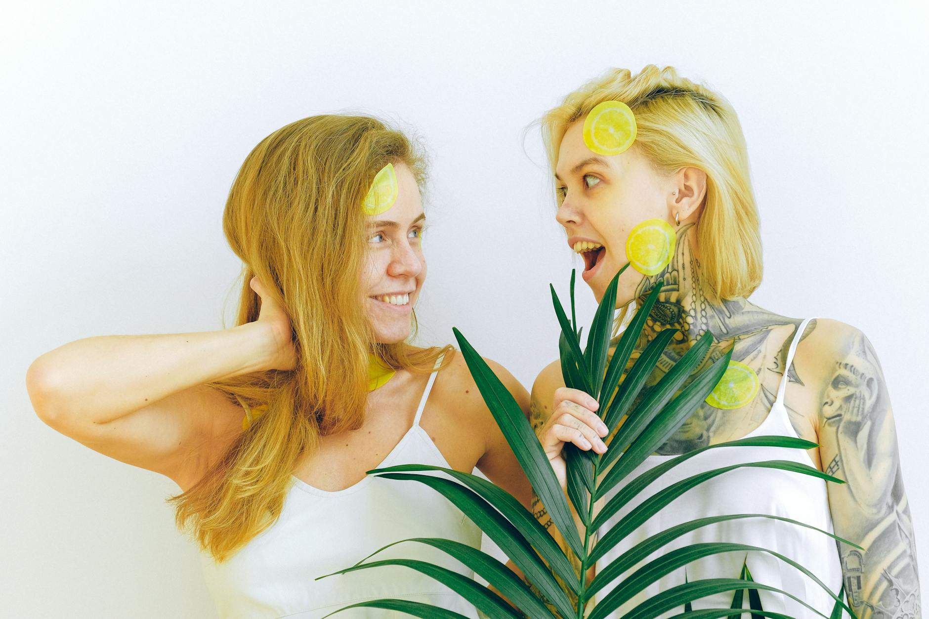 Two women expressing joy and connection, representing postpartum wellness and pleasure.