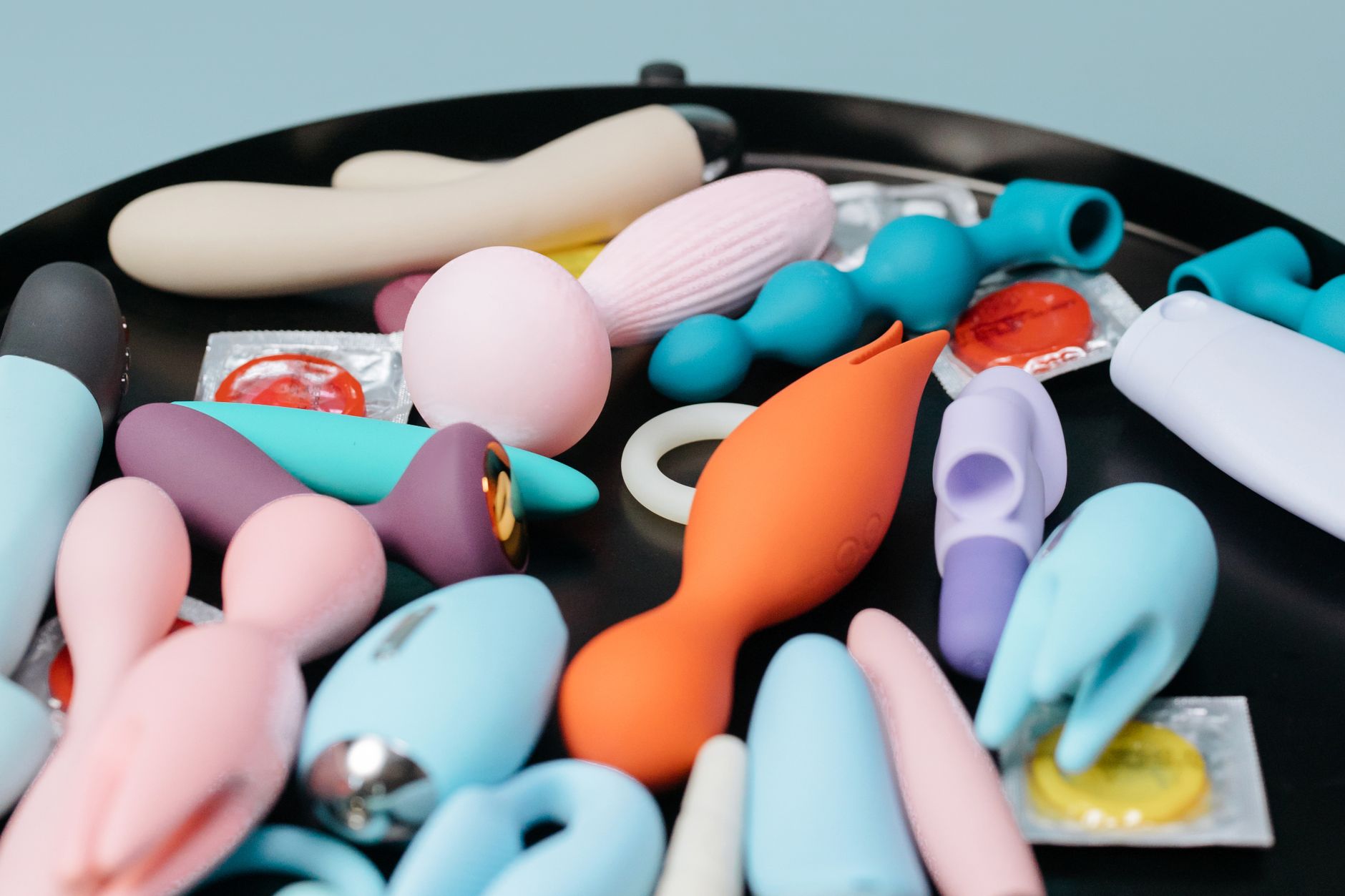 A person holding multiple vibrators, exploring different sensations and pleasure devices