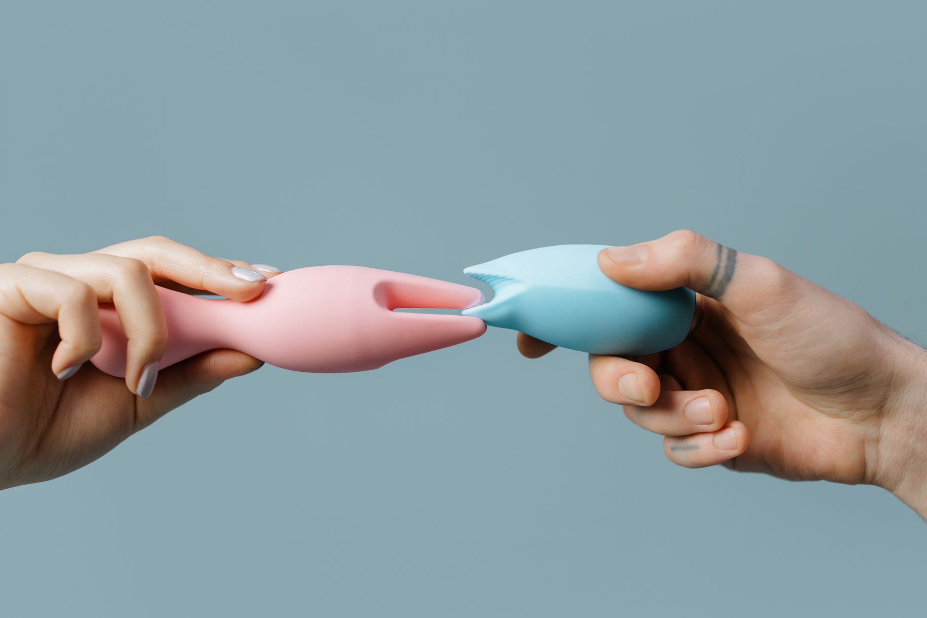 Woman with glasses holding vibrators against a purple background, representing pleasure reconnection