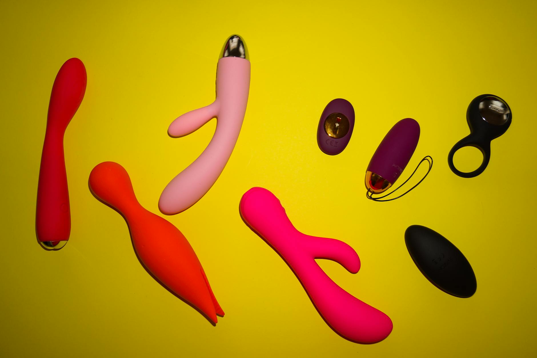 Hands holding pastel-colored silicone vibrators, representing self-care and personal pleasure
