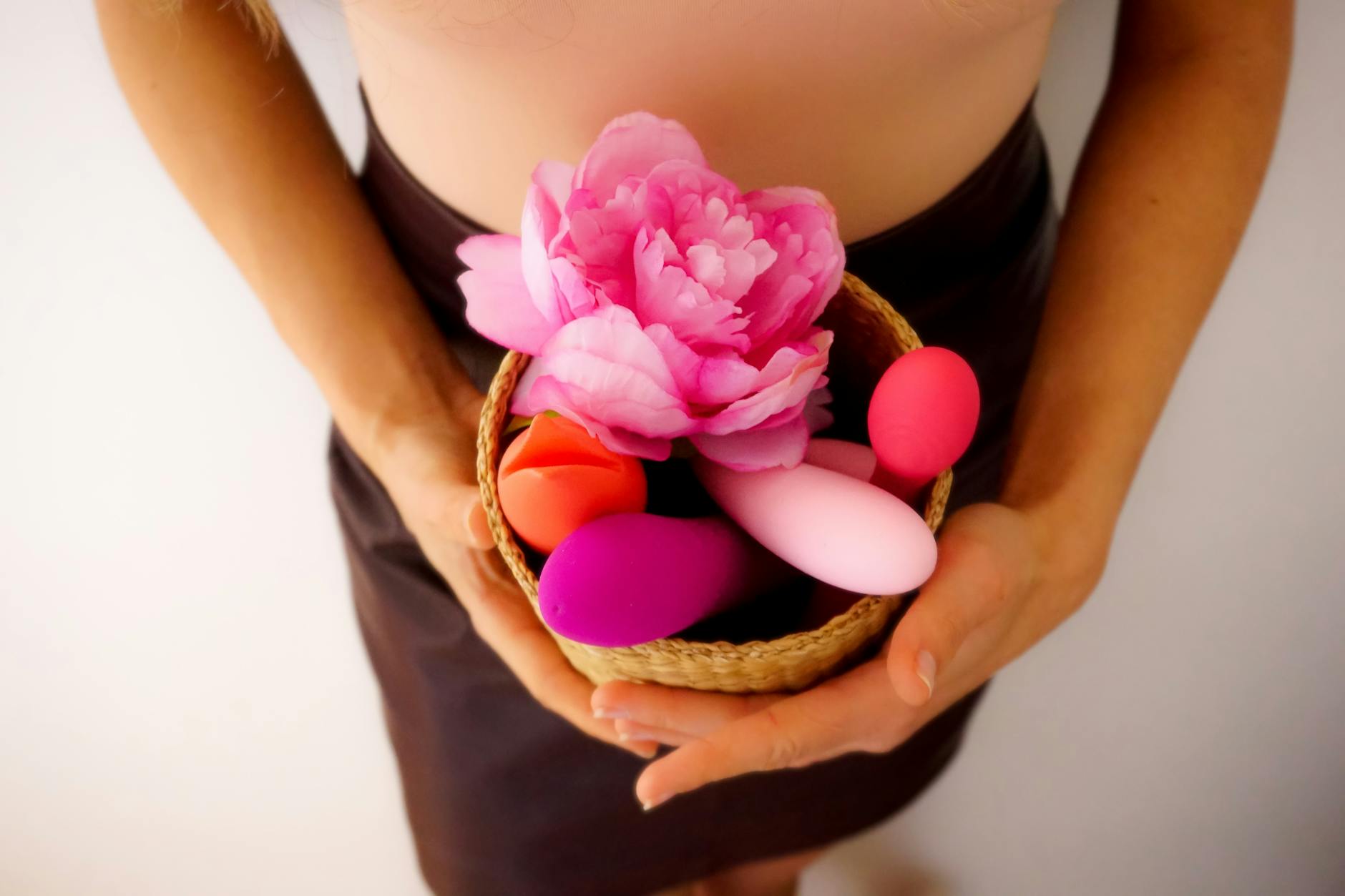 Close-up of hands holding a sleek blue vibrator, representing intimate self-exploration and heightened sensation